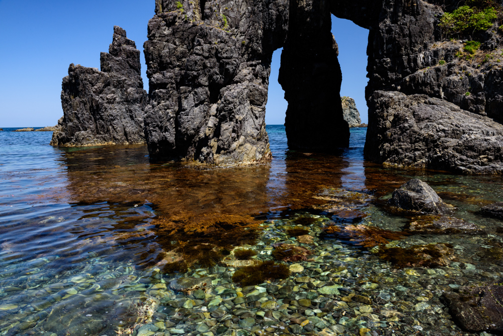 透明な海と奇岩のアーチ / Rocks and arches of unusual shape on clear sea
