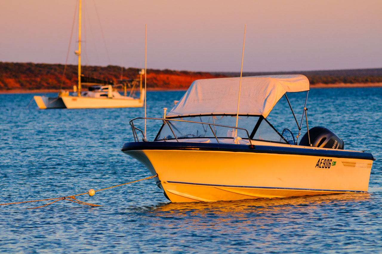 日の出に照らされるボートとシャーク湾の風景。Boat illuminated by sunrise and the view of Shark Bay.